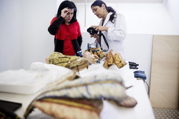 Maria João Vilhena e Conceição Ribeiro junto à mesa de trabalho onde inúmeros elementos estão a ser colados_ Nuno Ferreira Santos Maria João Vilhena e Conceição Ribeiro junto à mesa de trabalho onde inúmeros elementos estão a ser colados_ Nuno Ferreira Santos