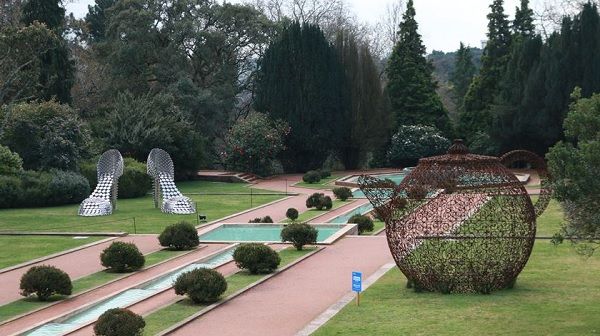 O par de sapatos feito com panelas e o bule em ferro são - além da banheira e do anel - as peças expostas na área do Parque de Serralves. O par de sapatos feito com panelas e o bule em ferro são - além da banheira e do anel - as peças expostas na área do Parque de Serralves.