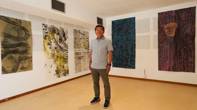 Artista chinês Yanbei no seu ateliê em Oeiras, rodeado de alguma das suas pinturas.© Paulo Spranger/Global Imagens