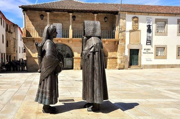 Escultura da autoria de José António Nobre, representando os trajes mirandeses.